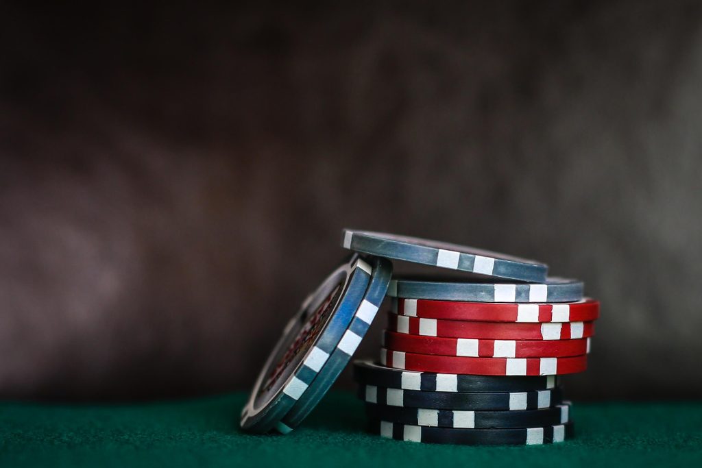 Colorful poker chips on a green surface.