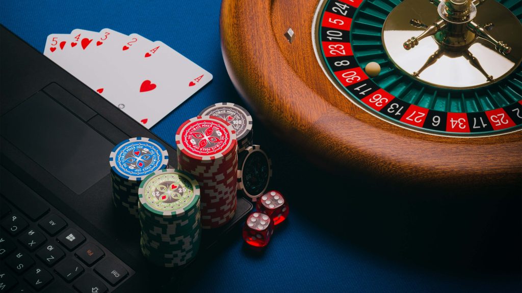 Playing cards, poker chips, and roulette wheel. 