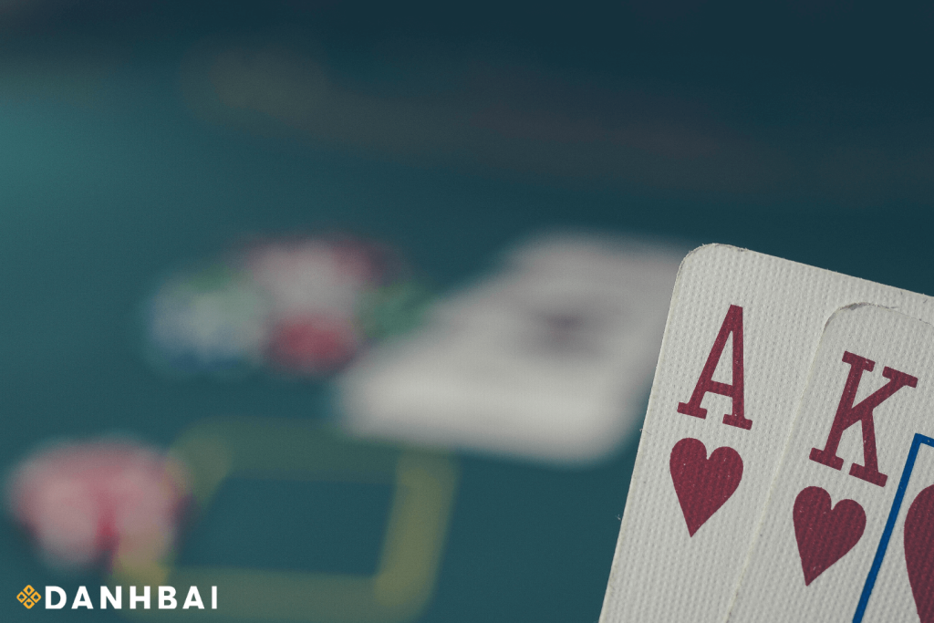 Ace and Queen cards placed on top of a stack of colorful casino chips.