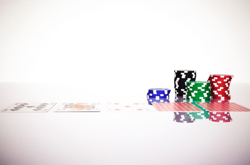 Chip poker và các lá bài trên bề mặt màu trắng.